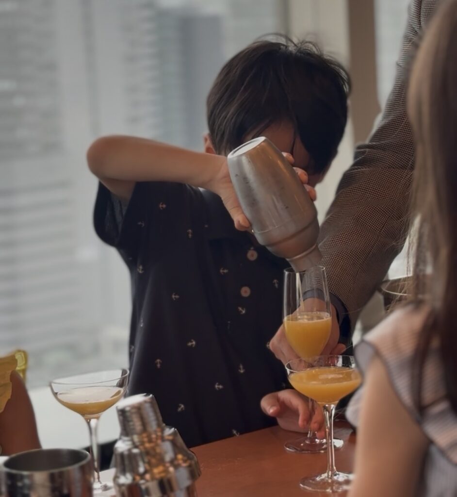 横浜ベイシェラトン「テーブルマナー for KIDS」子どもがバーテンダー体験でグラスに注いでいるところ