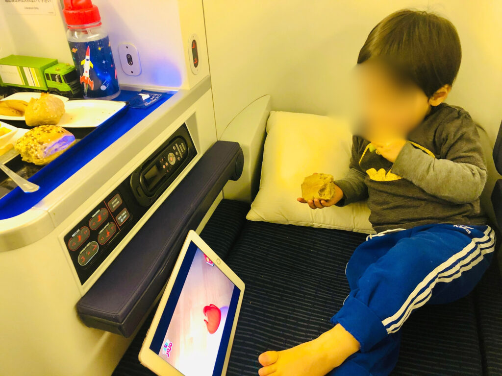 飛行機のビジネスクラスでくつろぐ2歳長男